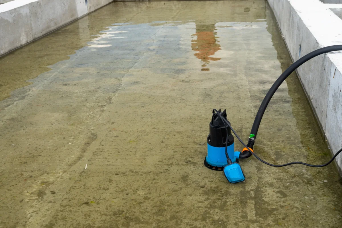 Submersible pump recovering standing water from a concrete work area