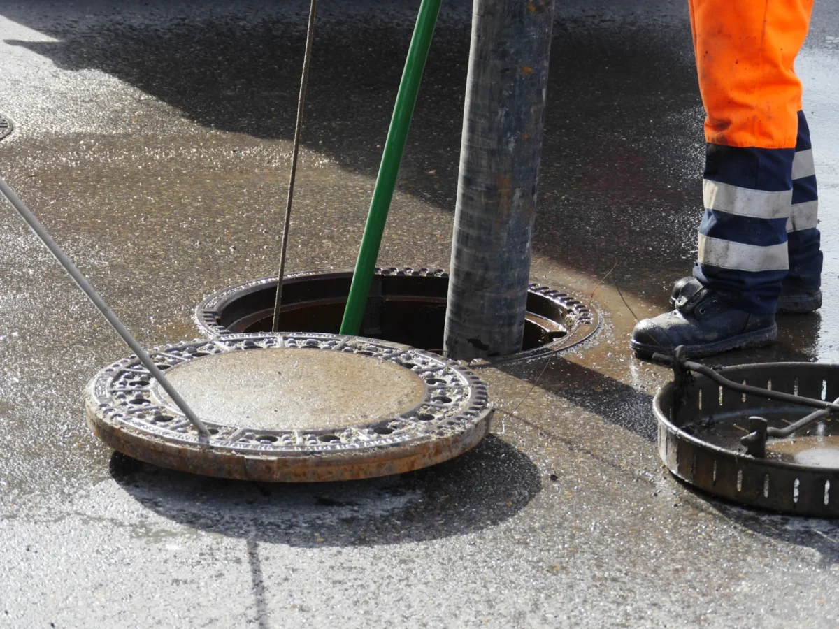 Drainage operative working with suction equipment at an open sewer chamber