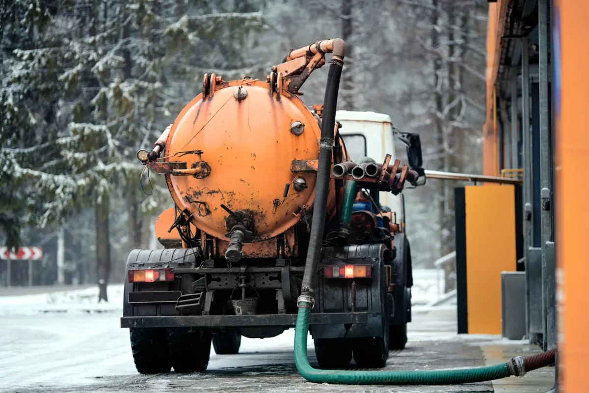 Vacuum tanker removing liquid waste and silt from a car-wash drainage system